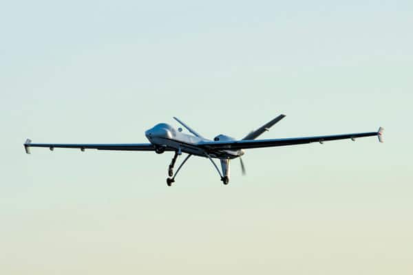 An uncrewed aerial system (drone) flying in front of a sunset