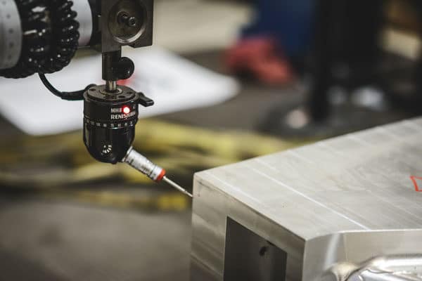 A CMM inspects a large metal part