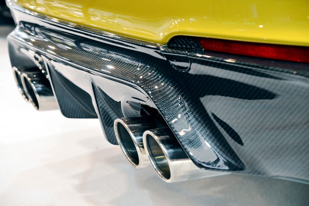 A carbon fiber car part on a yellow sports car